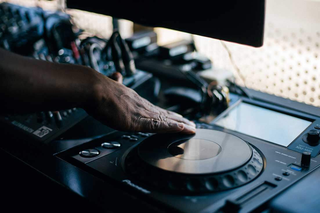 DJ hand on mixing deck / console