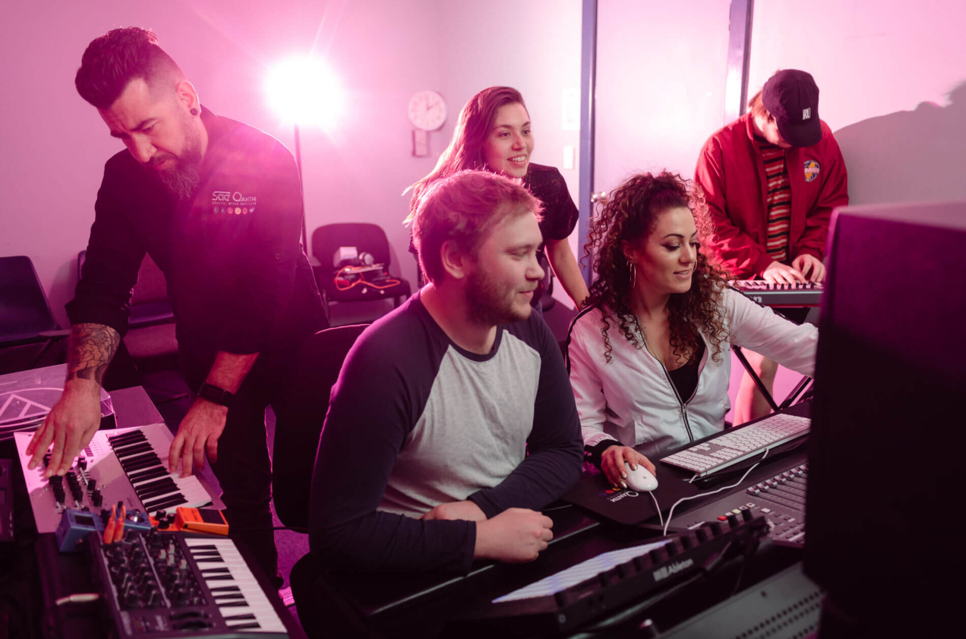 Group of Students and Lecturer in Music & Audio studio. Music production and editing.