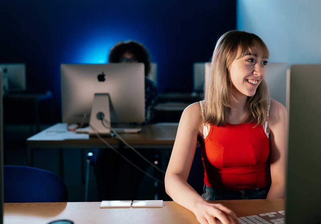 Girl sitting at desk in front pf desktop computer in study lab