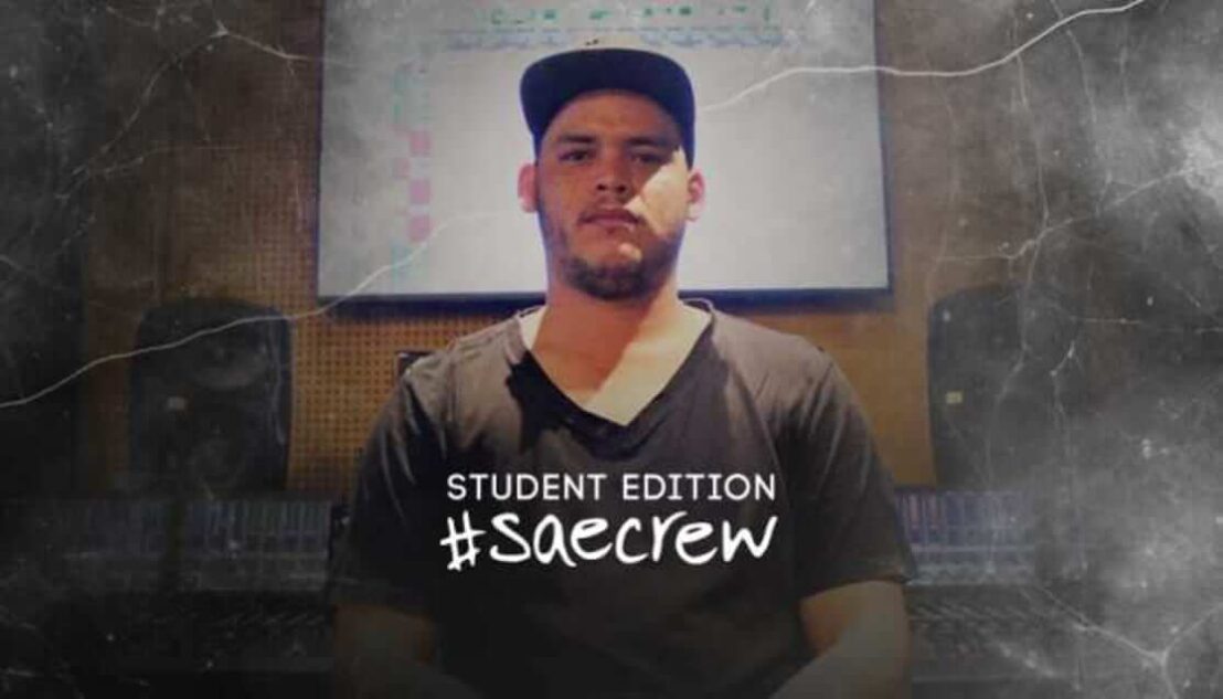 Student wearing a cap, sitting in front of a sound desk. Ash Saron