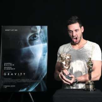 Man holding two film awards