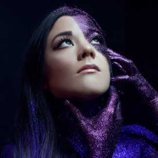 Woman with purple glitter on face and hands