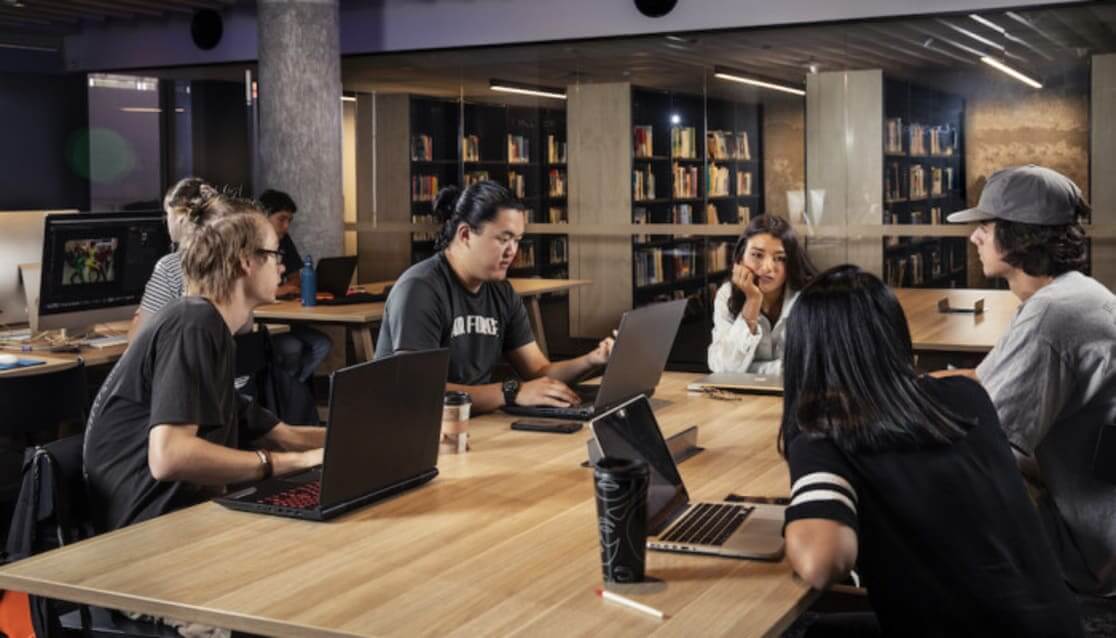 Students working in a library on computers