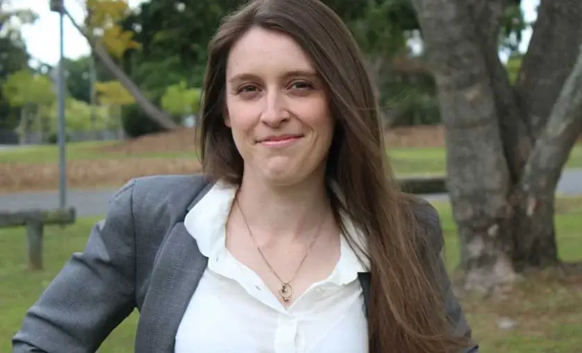 Maree Railton smiles to camera. Woman standing outside in a park