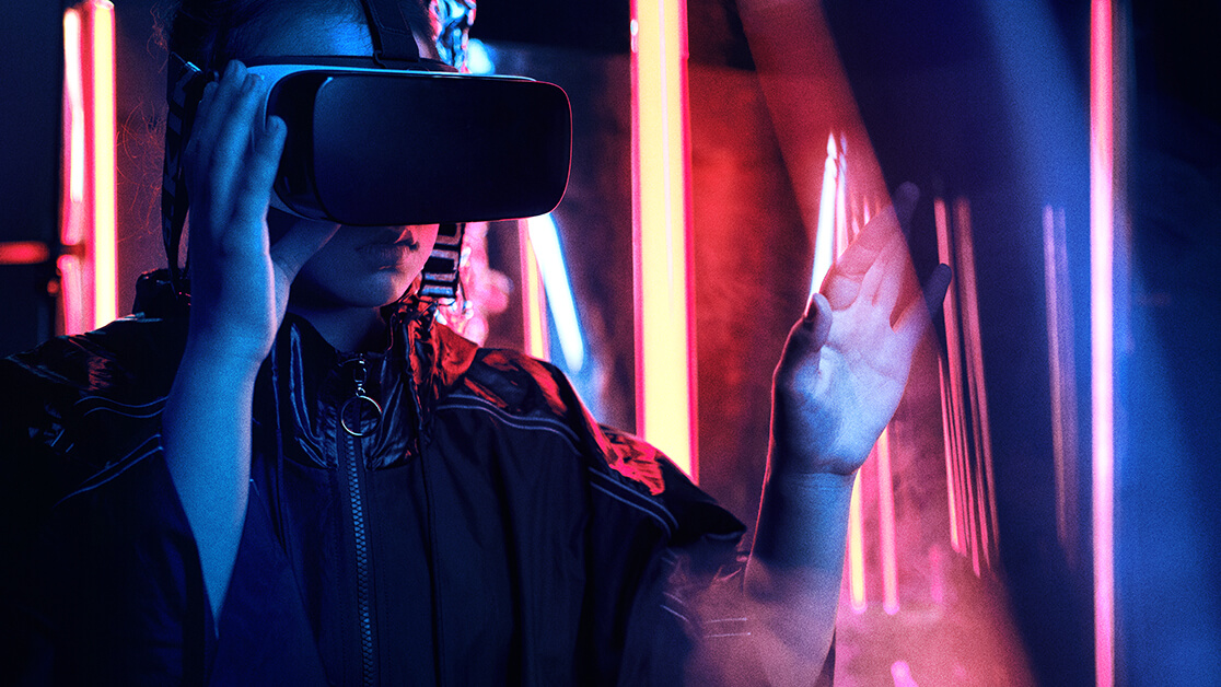 Person standing in front of fluorescent lights with VR headset on
