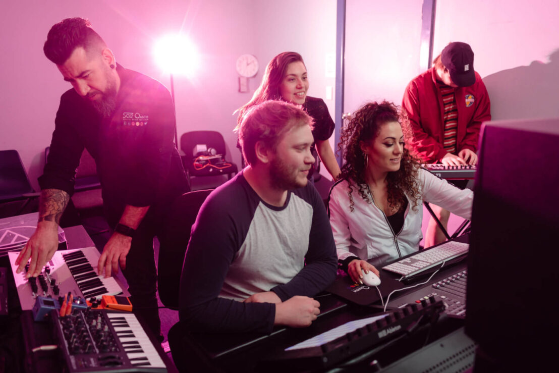 Group of Students and Lecturer in Music & Audio studio. Music production and editing.