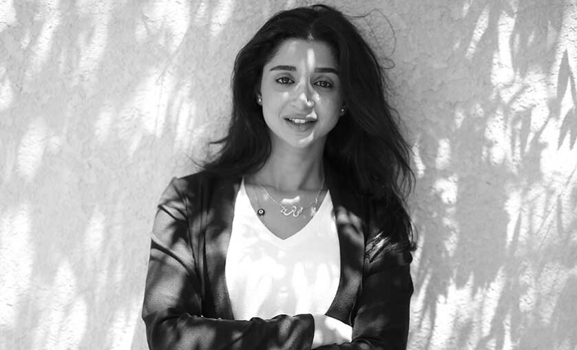 Female SAE graduate Sarah Khalaf poses against cement wall