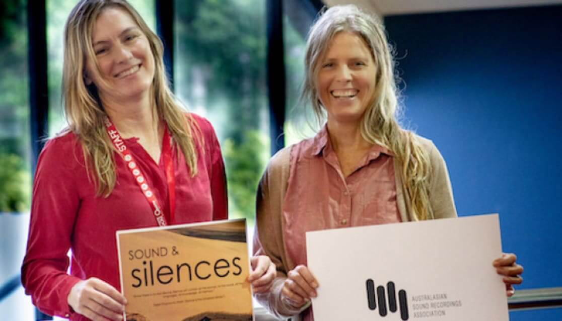 Two women holding sound recordings association signs