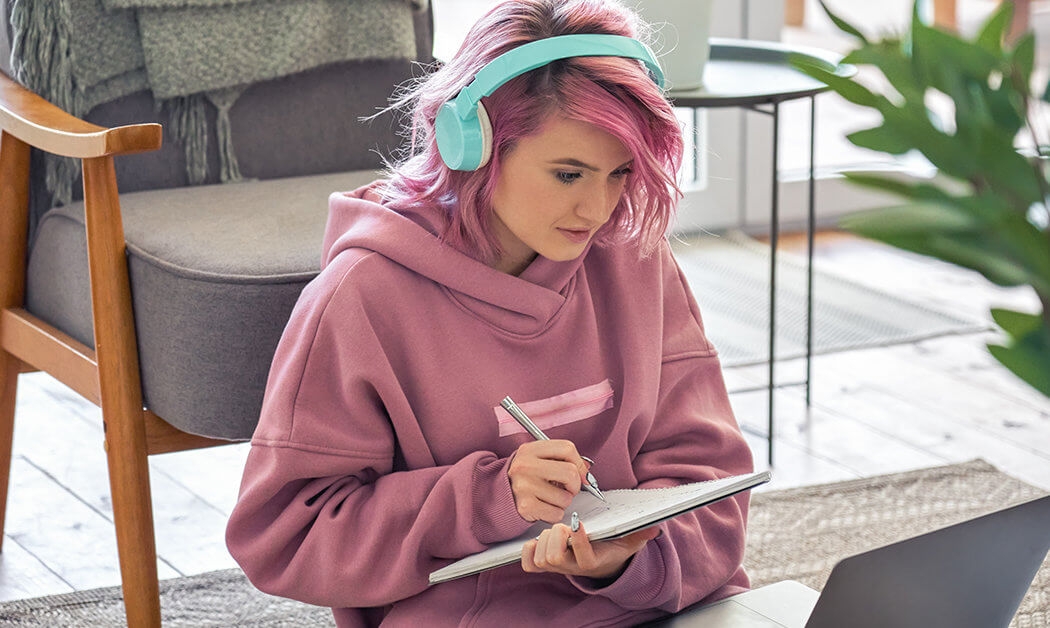 Woman with pink hair and pink hoodie, writing