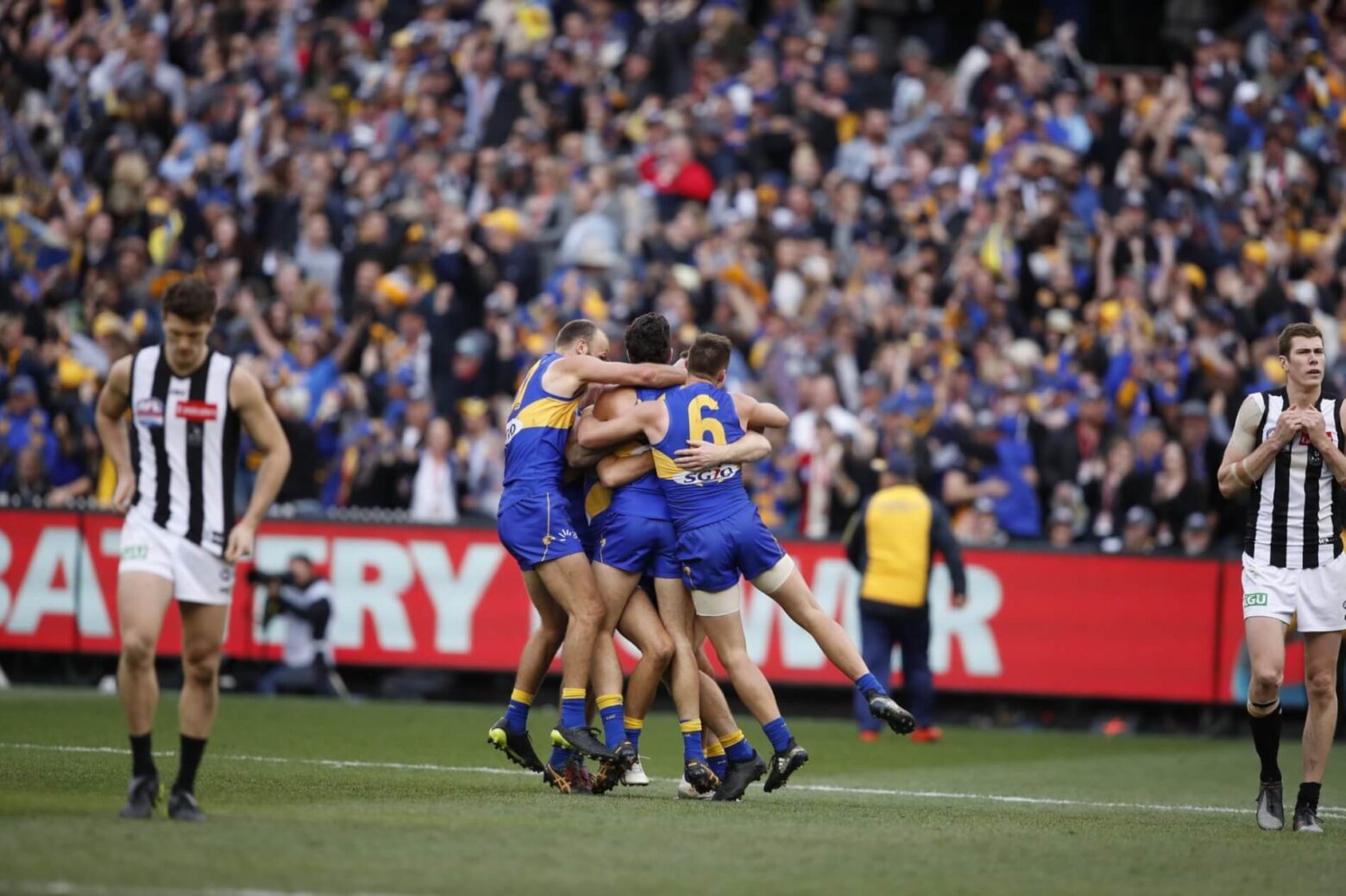 Team celebrating a win at a sports game. West Coast Eagles football team celebrating on field.