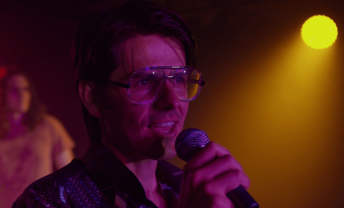 David Ciura wearing glasses, singing into microphone