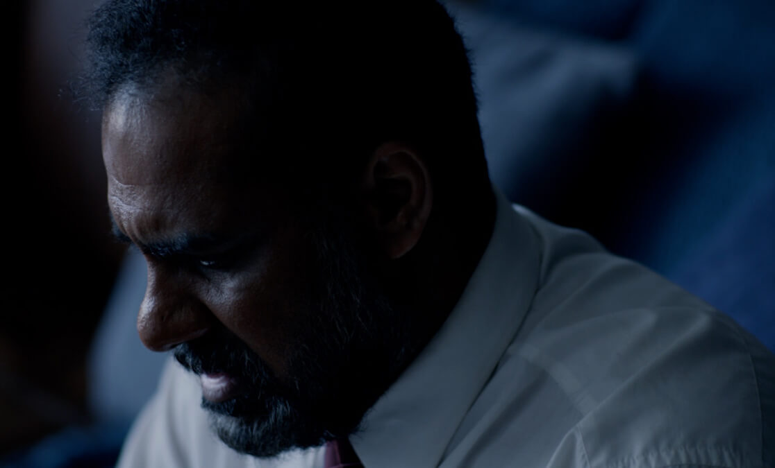 Screengrab of student film. Actor of colour looking distressed