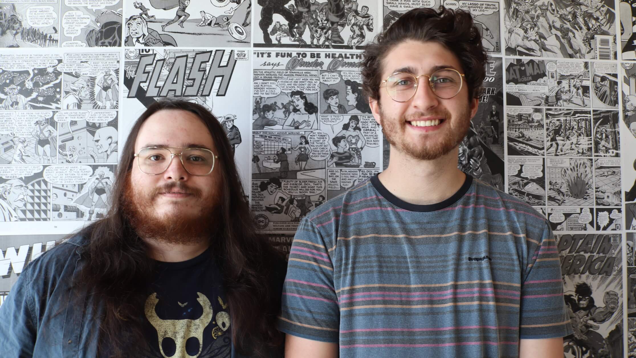 Game development students standing against black and white wall.