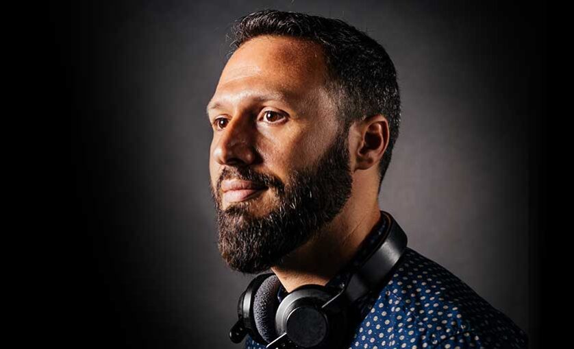 Man wearing headphones looks off in distance.