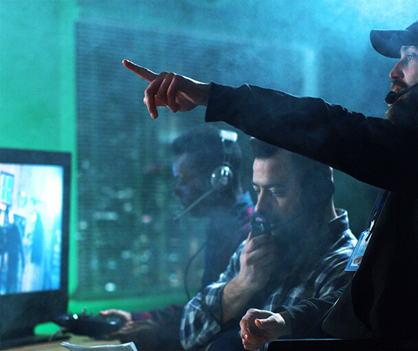 Three people filming, directing and editing film set and broadcast