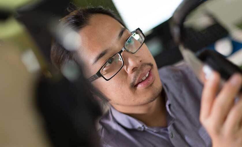 man with glasses looks on surrounded by camera equipment