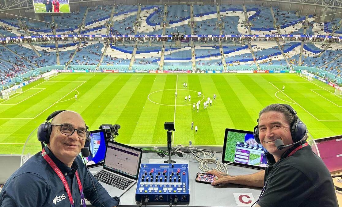 Two men commentating at a football match in Qatar