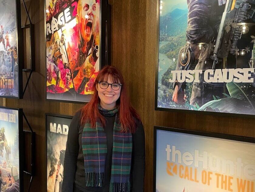 Woman with glasses standing in front of video game posters