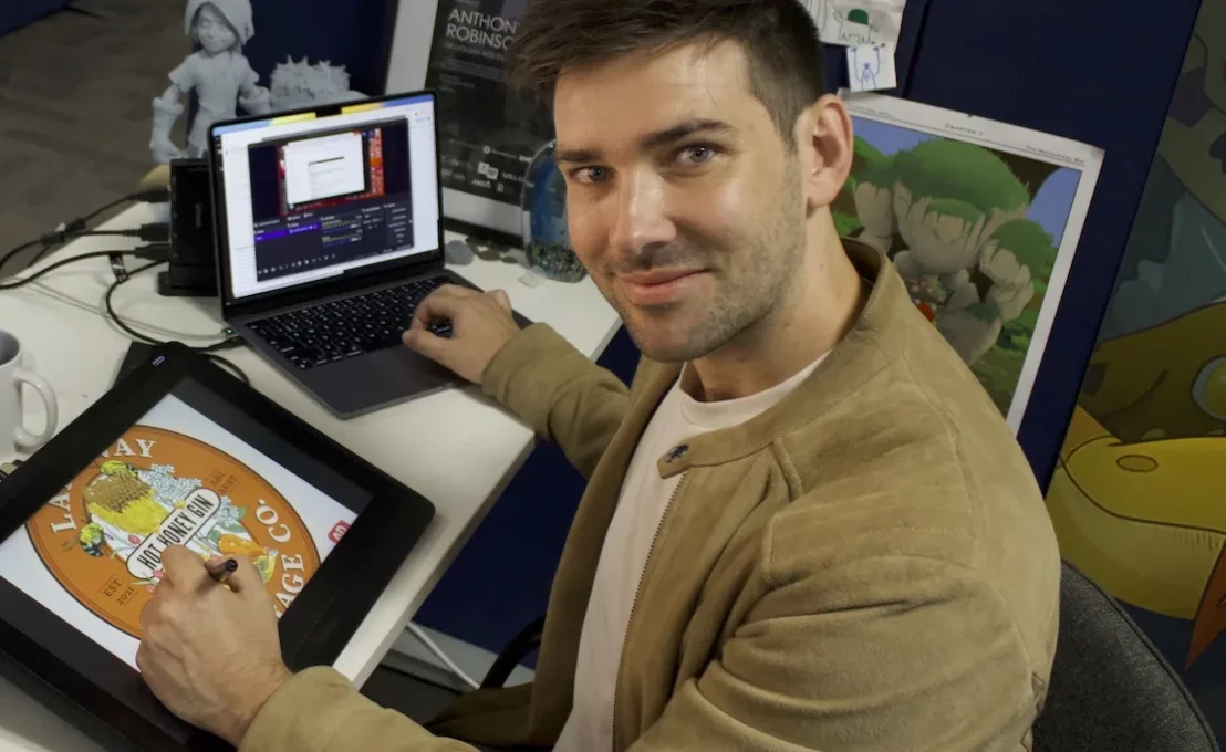 Anthony drawing with a digital pen and working on a laptop.