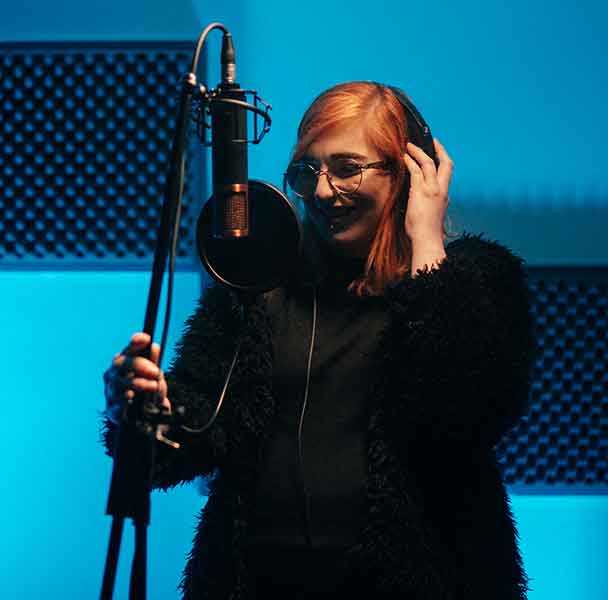 Girl in studio. Musician recording voice.