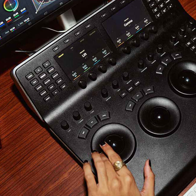 A hand at a desk operating a graphics tablet