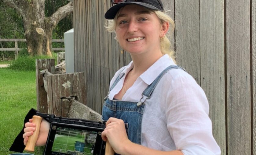 Photo of Mia Charleson standing outside, holding a film camera - SAE Bachelor of Film (Production) alumni