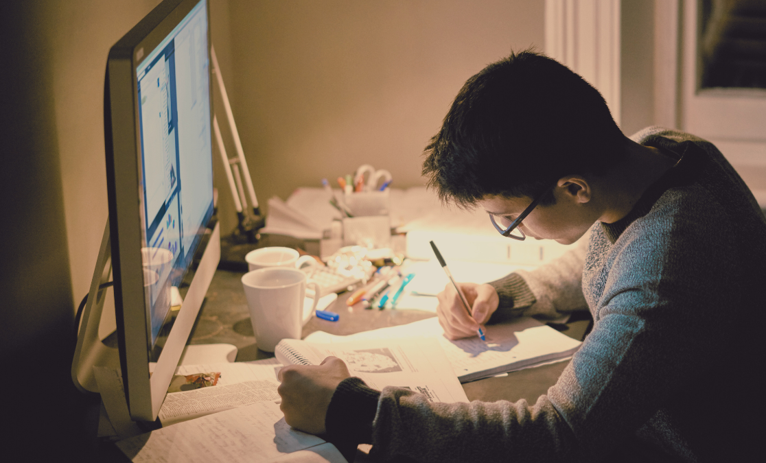 creative student working at a desk in front of a computer | screen fatigue