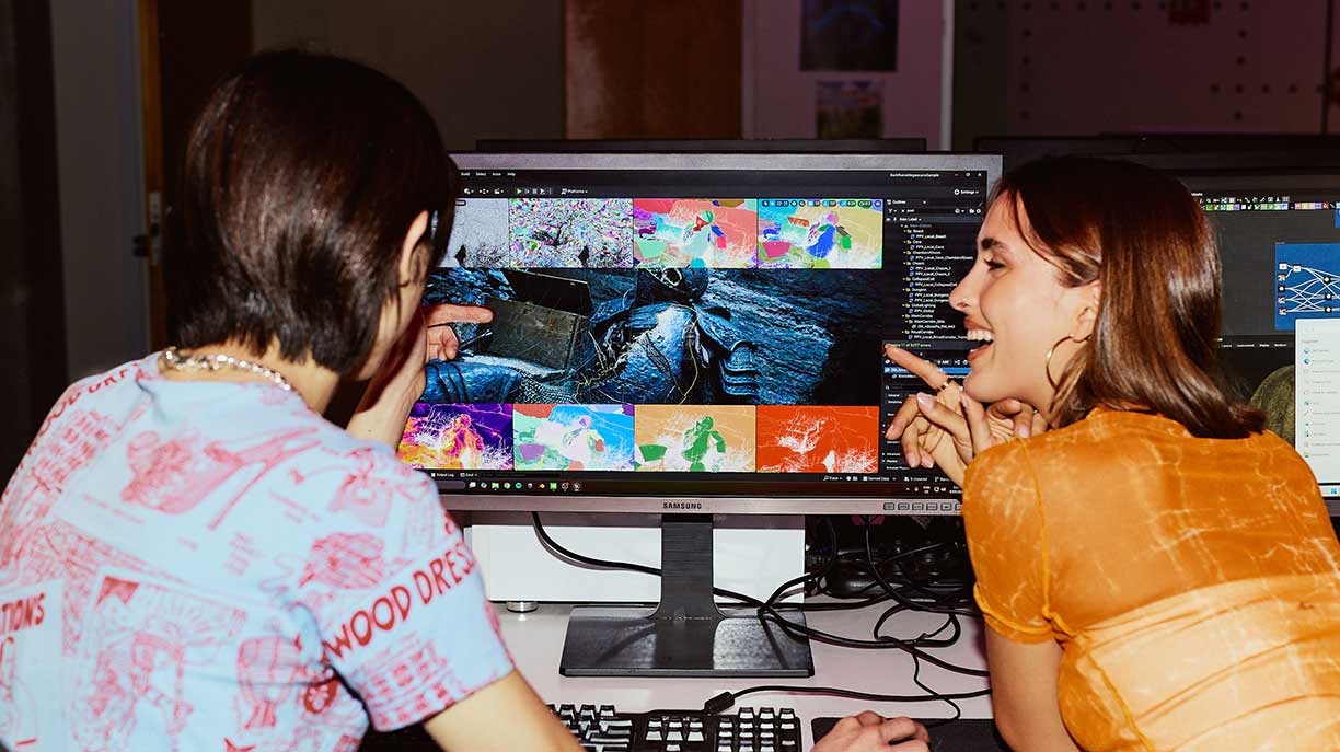 Rear view of two students sitting at a desk using a desktop computer with animation software - Diploma of 3D Animation