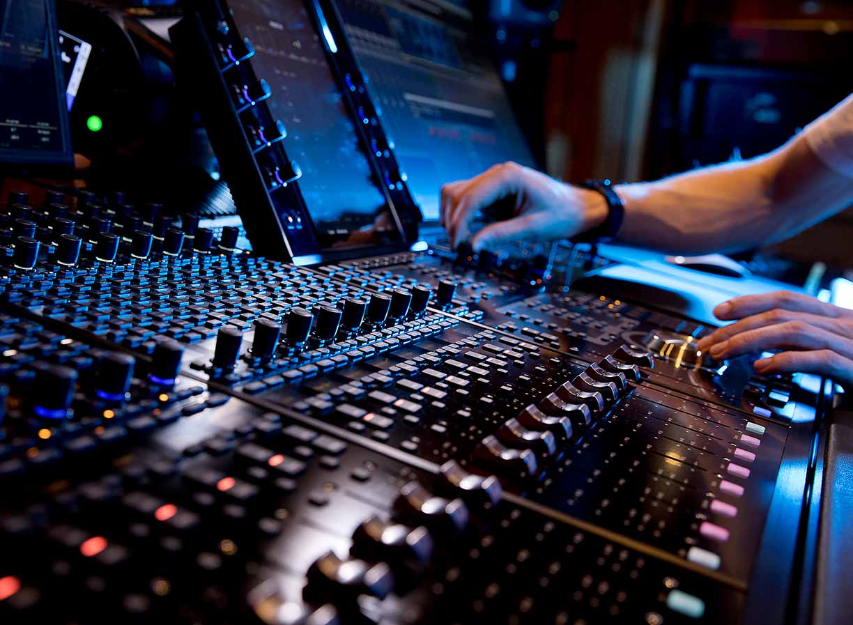 Close up photo of the two hands of an SAE Audio student operating audio engineering hardware