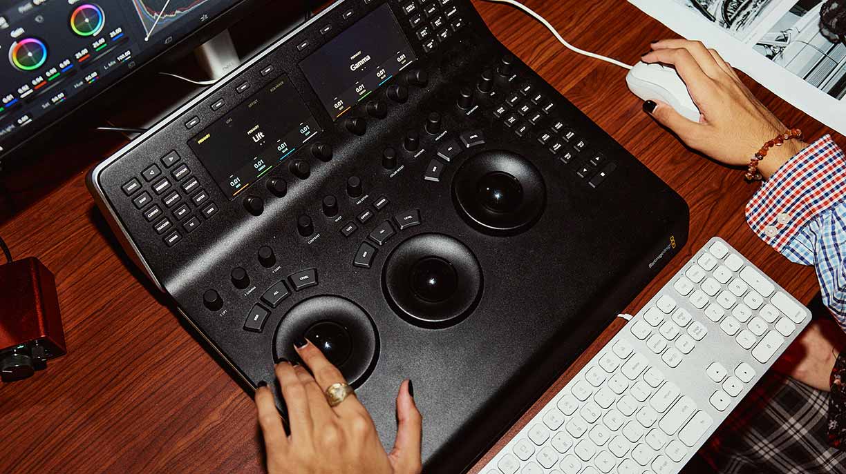 Two hands at a desk operating a graphics tablet