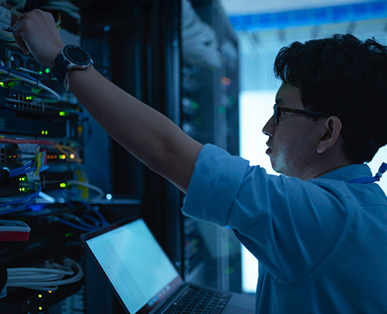 A man with glasses monitoring and operating computer hardware - Diploma of Cyber Security