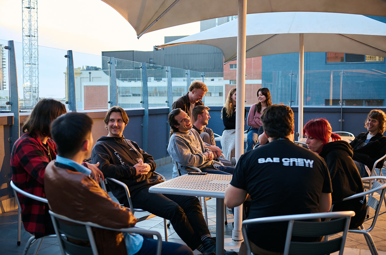 Several SAE students sitting in the balcony area of SAE Adelaide campus (1312x867)