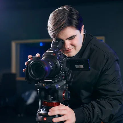 Film student looking through a camera viewfinder