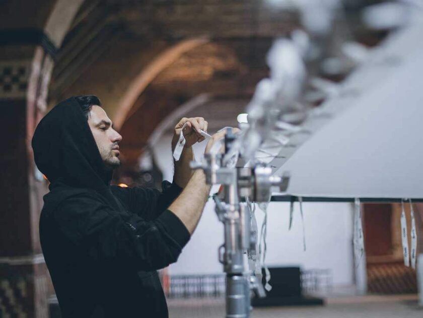 Male adjusting film / lighting screen on set