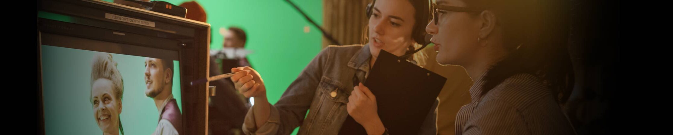 Study Film at SAE. Two people in film studio in front of editing camera.