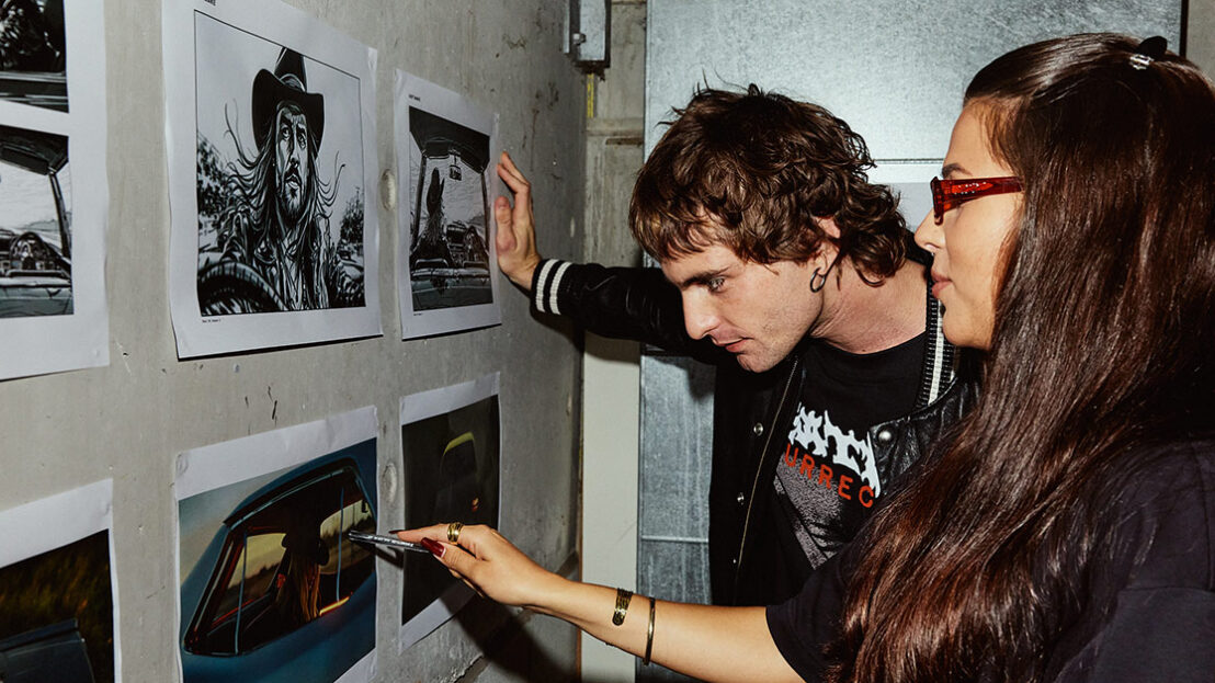 A male and female student looking at still images posted on a wall - SAE Open House event Brisbane (1116x628)