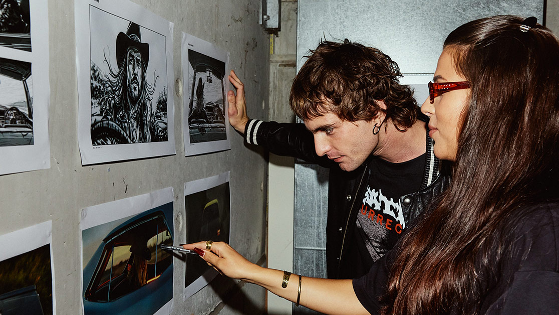 A male and female student looking at still images posted on a wall - SAE Open House event Brisbane (1116x628)
